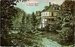Postcard showing views of houses by a brook with a wooden bridge in Cortland, Ohio.