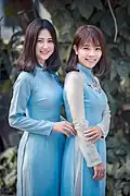 Two women wearing blue Áo dài