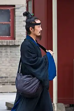 A Taoist man with a topknot and cross-collared robe.
