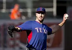 A man in a blue baseball jersey and cap