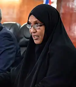 Headshot of Qaasim facing left and speaking