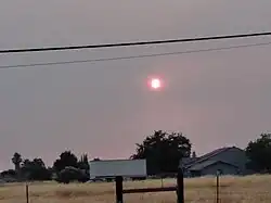Photograph of smoky sky near sunset in early August looking toward the west, in Sacramento, California. The smoke was produced by the wildfires.