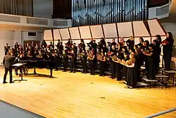 Wide view of a concert with high school choral students and Seraphic Fire singers on stage at the Wertheim Performing Arts Center in Miami.
