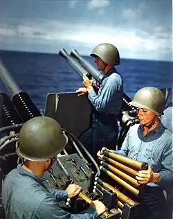 A Mark II talker helmet worn alongside M1 helmets by an 40 mm gun crew aboard the USS Alaska (CB-1) in 1945