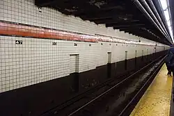 view of a subway track and wall from a platform at the 47th–50th Streets–Rockefeller Center station