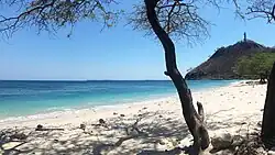 The beach with Cristo Rei of Dili in the background at right