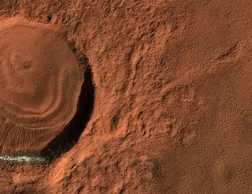 Close, color view of layered feature in crater, as seen by HiRISE under HiWish program. Different colors are due to different minerals.