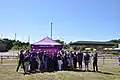 Images shows staff and volunteers celebrating outside a marquee.