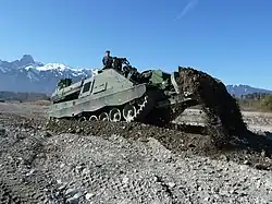 This AEV 3 Kodiak is using its front-mounted blade for dozing.