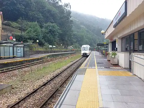 A narrow-gauge train at a station in Spain