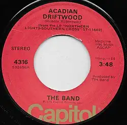 Single label for 'Acadian Driftwood' by the Band. Written by Robbie Robertson, From the LP Northern Lights Southern Cross, on Capitol Records. Performed and produced by The Band. 0:14 intro, track length 3:48. Capitol 4316.