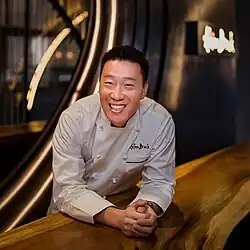 Chef Akira Back smiling in his restaurant