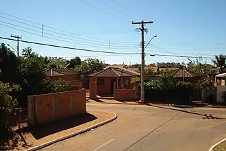 Corner of a street on an urban Indigenous village. Some houses with traditional shaped roofs can be seen.