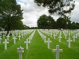 A photograph of white grave markers on green grass at the Normandy American Cemetery and Memorial near Omaha Beach in France