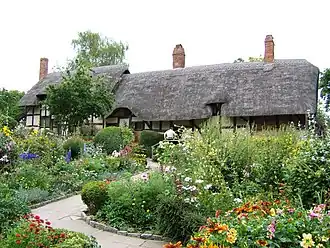 An old thatched cottage set within colourful gardens