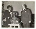 Burke, left, presenting her bust of Samuel Huntington (1938) to the principal of Samuel Huntington Junior High School in Jamaica, Queens