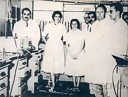 Black and white photo of several scientists facing the camera