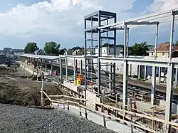 The metal framework of a below-ground railway station under construction