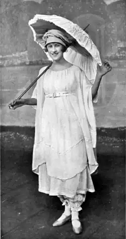 Young white woman in summer frock carrying large parasol