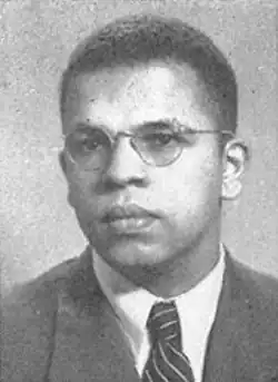 A black and white photo of McAdoo wearing a suit and glasses.