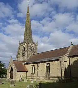 A portrait image of the church showing the tower and south porch