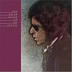 A solarized photograph of Dylan's face in profile facing a burgundy stripe with the album's name in white