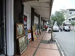 Kaki lima or five-foot way along Braga Street in Bandung, Indonesia, occupied by street artist selling paintings