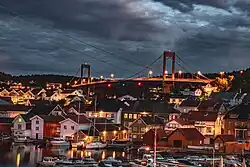 This image captures Brevik Marina at night with . The long exposure shot illuminates the marina, bridge, boats, and waterfront houses, creating a warm and vibrant scene. Foto: Sandesh Aryal