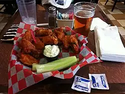 Buffalo wings with blue cheese dressing, served with lager beer