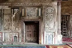 Marble decoration in the prayer hall, including a panel of square Kufic above the door in the middle. (2015 photo, prior to recent restoration)