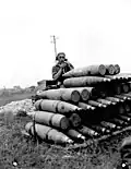 Canadian signaler with shells during a shoot, France July 1944.