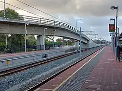 A curved concrete bus on-ramp to the median of a freeway