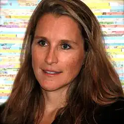 Professional headshot of Catherine Gund at the Tribeca Film Festival in New York City. She has short hair and is wearing a black shirt.