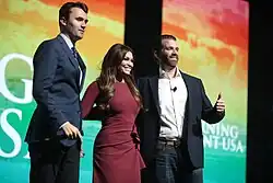 Guilfoyle with Charlie Kirk (left) and Donald Trump Jr. (right), pictured at the Palm Beach County Convention Center in 2019