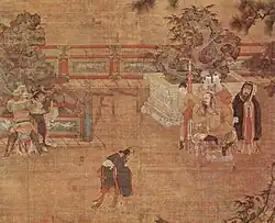 A painting of a play being staged in a courtyard. In the center, a man in loose black robes appears in mid-bow or mid-dance. To the left, two men dressed as guards are holding a third man, dressed in the same attire as the man in the center. To the right, a heavy set man sits in a throne. Behind him stand three women in white face paint and a man dressed in the same attire as the man in the center.