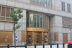 One of the building's entrances, which has bronze revolving doors beneath a rounded bronze window frame