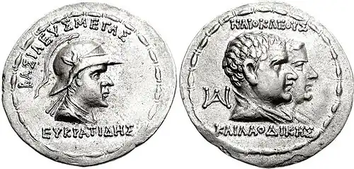 Coin of Eucratides with parents Heliocles and Laodice. Greek legends: ΒΑΣΙΛΕΥΣ ΜΕΓΑΣ ΕΥΚΡΑΤΙΔΗΣ, "Great King Eucratides", and ΗΛΙΟΚΛΕΟΥΣ ΚΑΙ ΛΑΟΔΙΚΗΣ, "Son of Heliocles and Laodice".