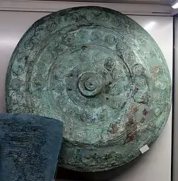 Funerary furniture from male tomb 871 of the necropolis of Casal del Fosso, circa 730-720 BC. Circular bronze parade shield decorated with rows of raised dots.