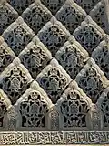 Sebka motif filled with arabesques in the carved stucco decoration of the Cuarto Real de Santo Domingo in Granada, Spain