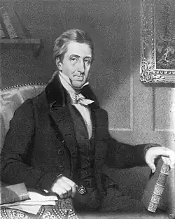 Image of a fair-skinned man, wearing early 19th century suit, sitting and holding a book