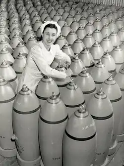 A worker tightens nose plugs of 500-pound bombs