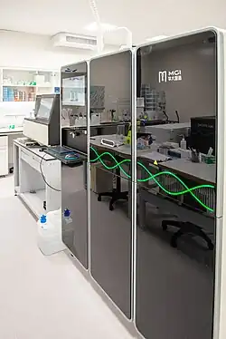 Modern DNA sequencing machine with multiple sample chambers and green DNA helix graphics