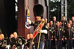The U.S. Army Band drum-major shown with choir behind him.