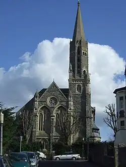 Façade of church seen from the northwest. The façade, west tower, and spire are all that remain of the church built in 1878.