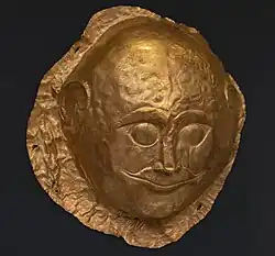 Gold male death-mask made of sheet metal with repoussé details portraying the deceased's eyes opened, the only one in Shaft Grave IV
