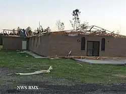 A brick building with it's roof removed. Trees can be seen in the background. On the bottom left, it says "NWS BMX".