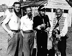 1948 B&W photograph of Donn Reynolds (far left) on the film set of Eureka Stockade standing with Peter Finch, Grant Taylor, and Sydney Loder (New South Wales, Australia).