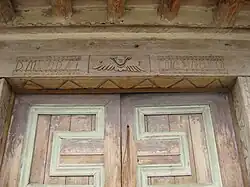 Inscription over front doors by Nicolas Apodaca
