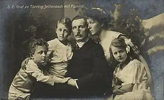 Black and white postcard showing a couple sitting with their two sons and daughter.