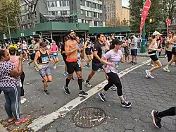 Group of runners with spectators in the foreground.